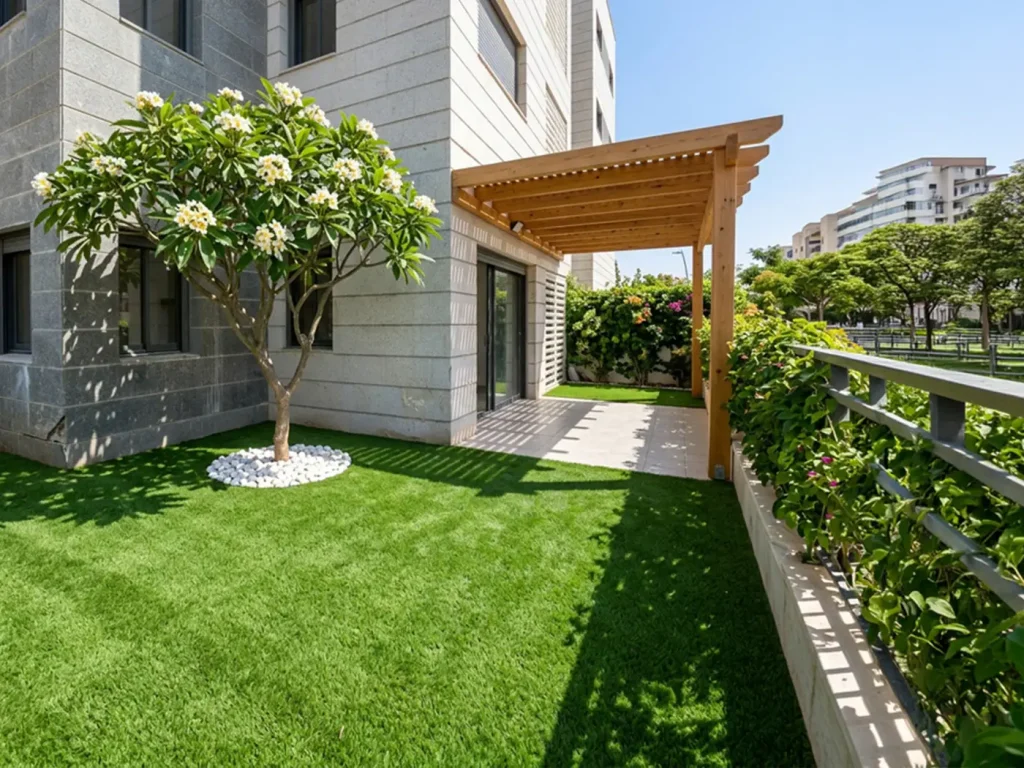 Completed garden transformation in Carmei Gat with synthetic grass, wooden pergola, plumeria tree, planting and outdoor patio