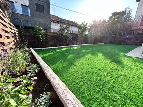Rechovot garden transformation featuring artificial grass, custom stone planters and fruit trees