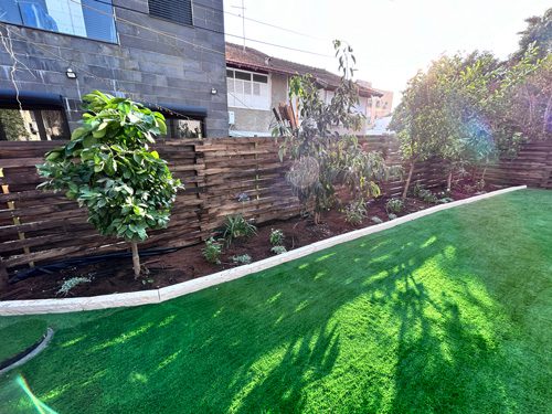 Completed residential garden landscaping project in Rechovot, Israel with synthetic lawn and new planting